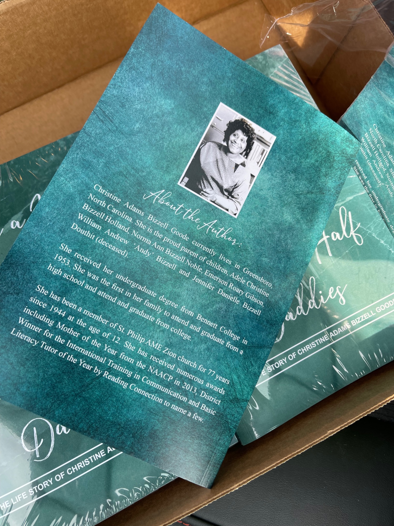 Printed author biography books packaged in a shipping box