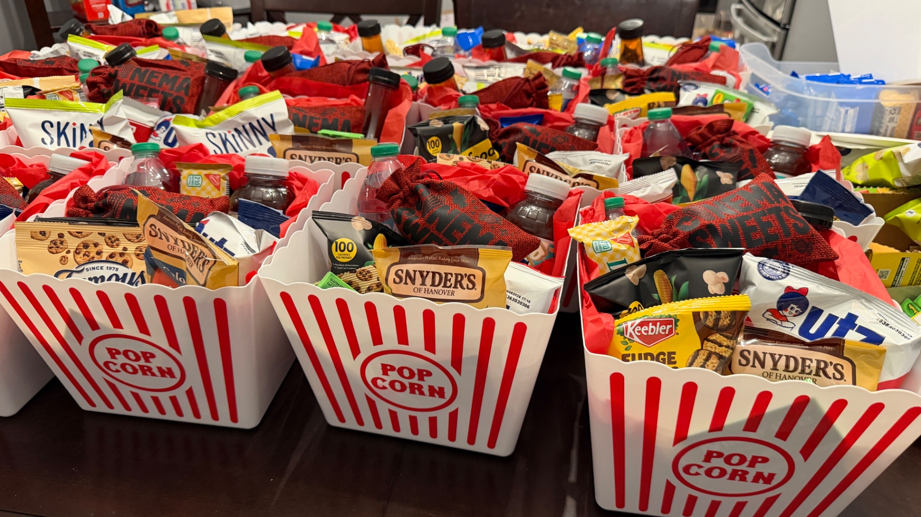 Movie night favor bins filled with snacks and branded treat bags